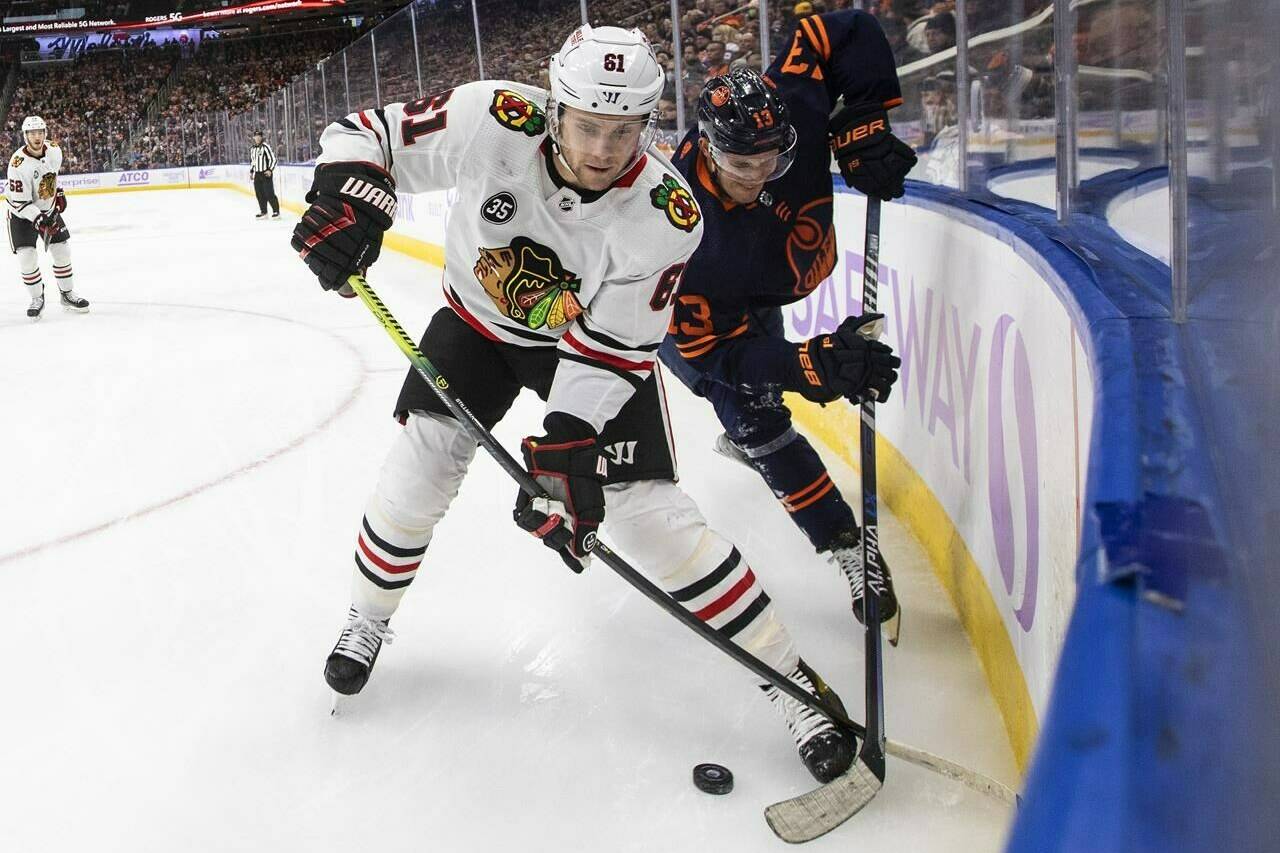 Chicago Blackhawks’ Riley Stillman (61) and Edmonton Oilers’ Jesse Puljujarvi (13) battle for the puck during first period NHL action in Edmonton on Saturday, November 20, 2021.THE CANADIAN PRESS/Jason Franson