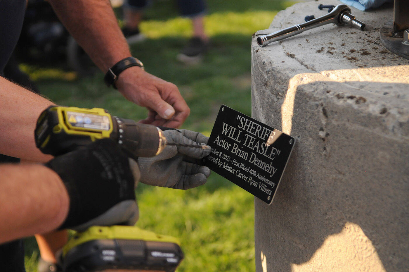 A plaque is attached to the base of a carving of Sheriff Will Teasle from the movie Rambo First Blood, played by actor Brian Dennehy, during an unveiling on Saturday, Oct. 8, 2022 at the Rambo First Blood 40th Anniversary celebrations in Hope. (Jenna Hauck/ Black Press Media)