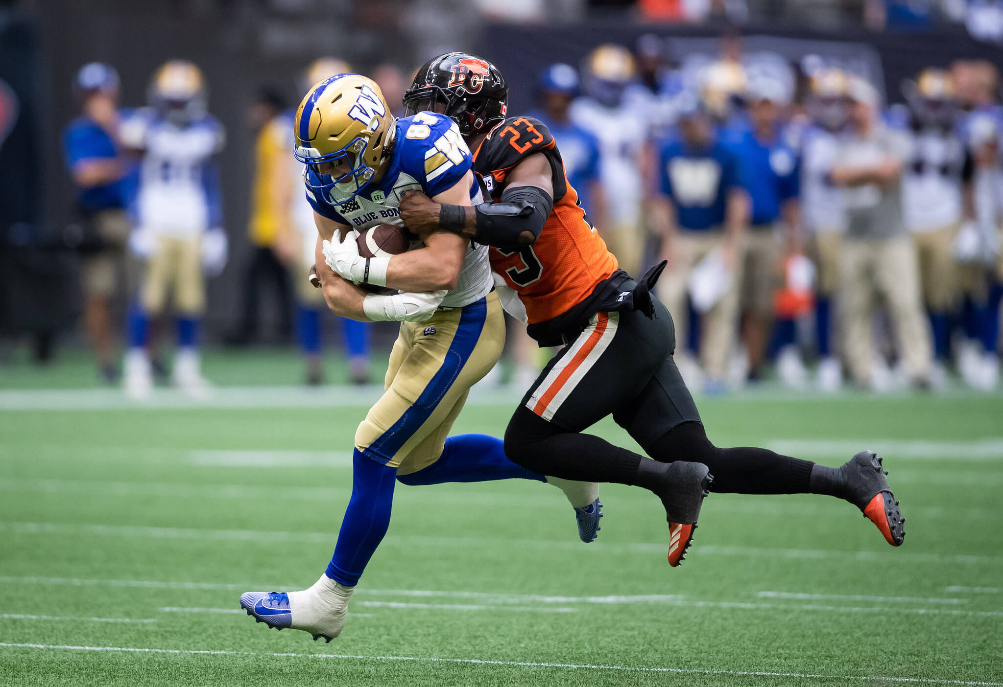 Winnipeg Blue Bombers' Dalton Schoen (83) is tackled by B.C. Lions' Delvin Breaux Sr. (23) after making a reception during the second half of CFL football game in Vancouver, on Saturday, July 9, 2022. THE CANADIAN PRESS/Darryl Dyck