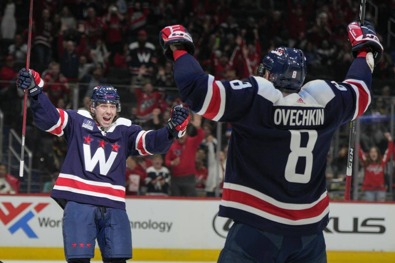 Washington Capitals left wing Alex Ovechkin (8) celebrates after his goal with center Dylan Strome (17) during the first period of an NHL hockey game against the Vancouver Canucks, Monday, Oct. 17, 2022, in Washington. (AP Photo/Jess Rapfogel)