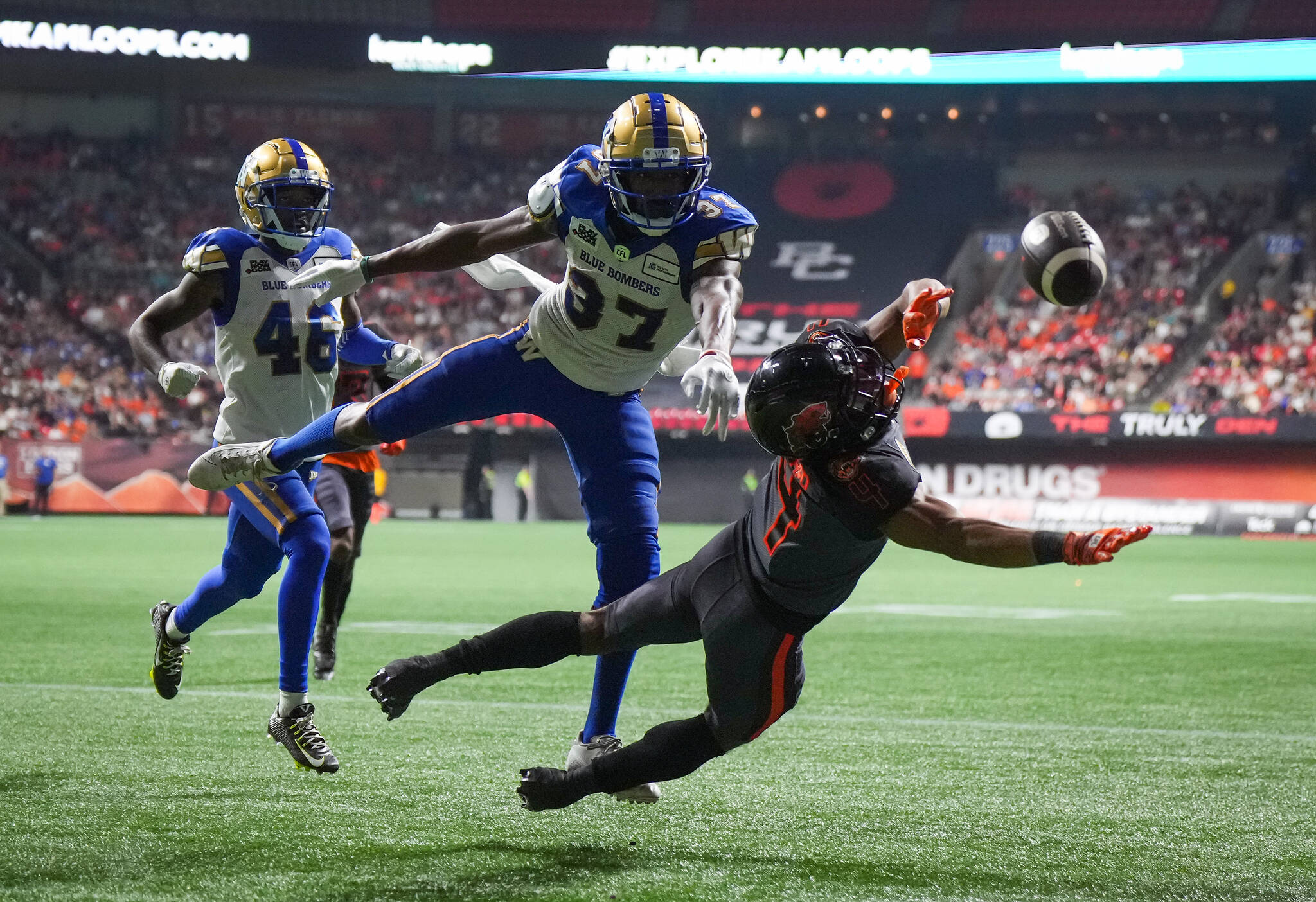 B.C. Lions’ Keon Hatcher (4) fails to make the reception in the end zone as Winnipeg Blue Bombers’ Brandon Alexander (37) defends and Desmond Lawrence (46) watches during the first half of CFL football game in Vancouver, on Saturday, October 15, 2022. THE CANADIAN PRESS/Darryl Dyck