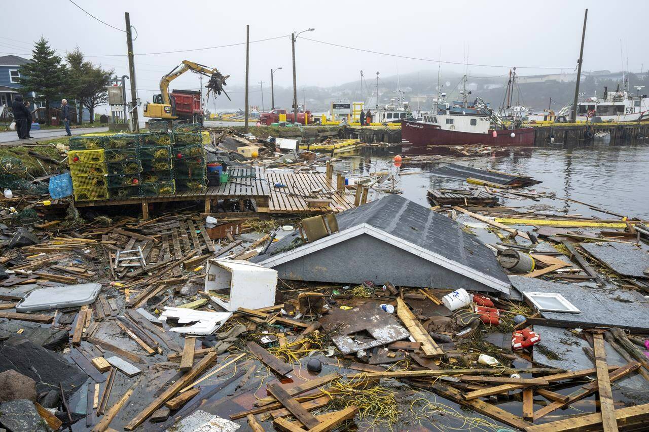 Heavy machinery clears washed-up buildings and rubble in the harbour in Burnt Island, Newfoundland and Labrador, on Tuesday, Sept. 27, 2022. An initial estimate by Catastrophe Indices and Quantification Inc. suggests hurricane Fiona did $660 million in insured damage. THE CANADIAN PRESS/Frank Gunn