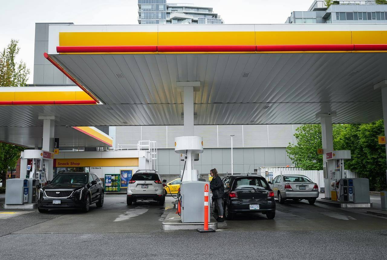 People fuel up vehicles at a Shell gas station in Vancouver on Saturday, May 14, 2022. Vancity says it is launching a program that will allow its Visa credit card holders to track the estimated carbon emissions of their purchases. THE CANADIAN PRESS/Darryl Dyck