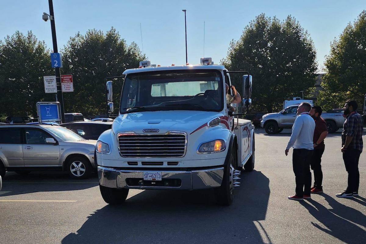 A Brian’s Towing truck driver talking to Walmart Kelowna management in the parking lot after a woman said she witnessed the driver allegedly drop a run down RV in the parking lot Oct. 18, 2022 (submitted)
