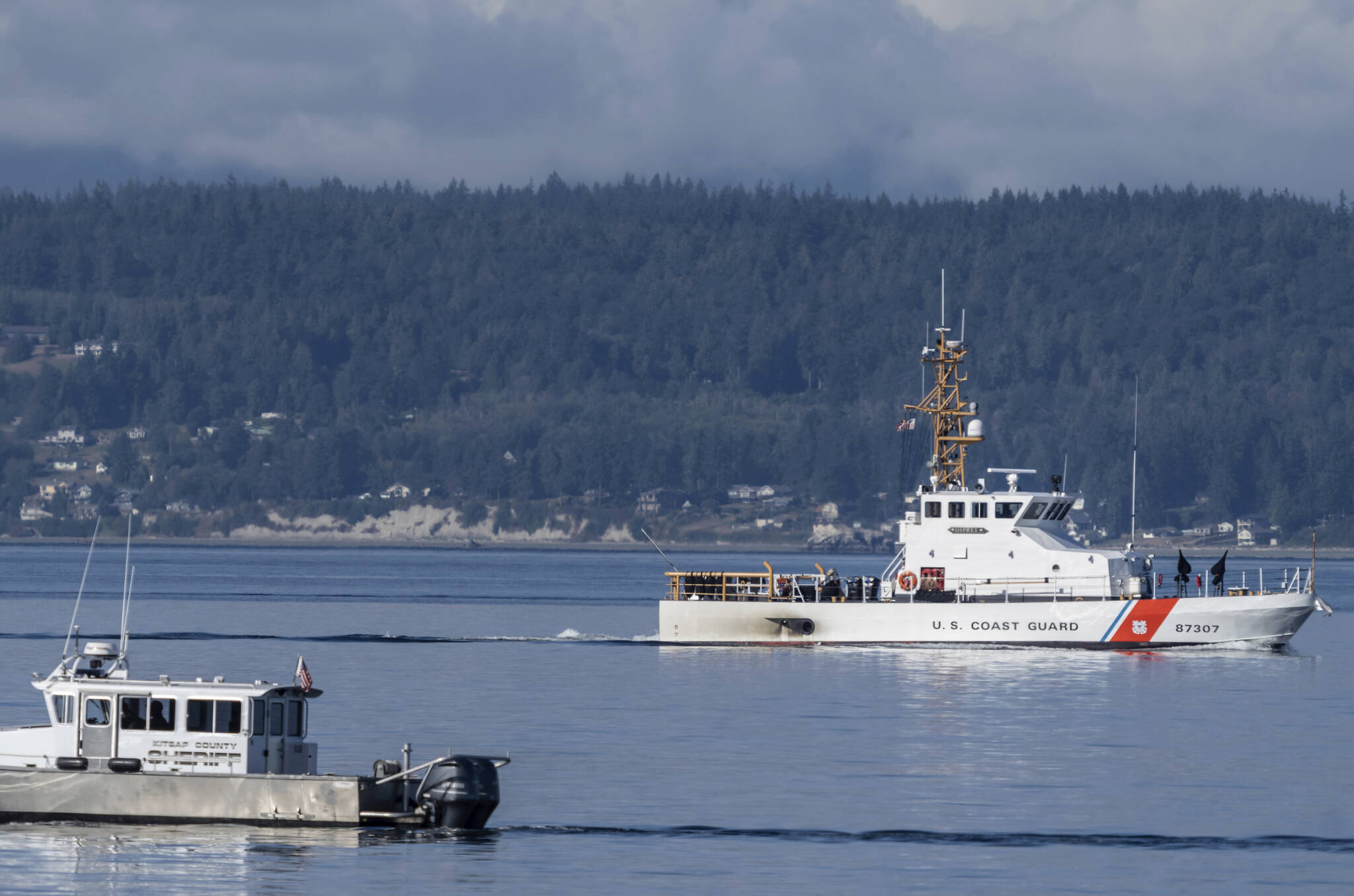 FILE - A U.S. Coast Guard boat and Kitsap, Wash., County Sheriff boat search the area, Monday, Sept. 5, 2022, near Freeland, Wash., on Whidbey Island north of Seattle where a chartered floatplane crashed the day before, killing 10 people. Crews later this month will begin trying to recover the wreckage. rews later this month will begin trying to recover the wreckage of a seaplane that crashed in Puget Sound off Whidbey Island in Washington state. The National Transportation Board said Friday, Sept. 16, 2022 it will work with the Navy to collect the wreckage of the DHC-3 Turbine Otter. (AP Photo/Stephen Brashear, File)