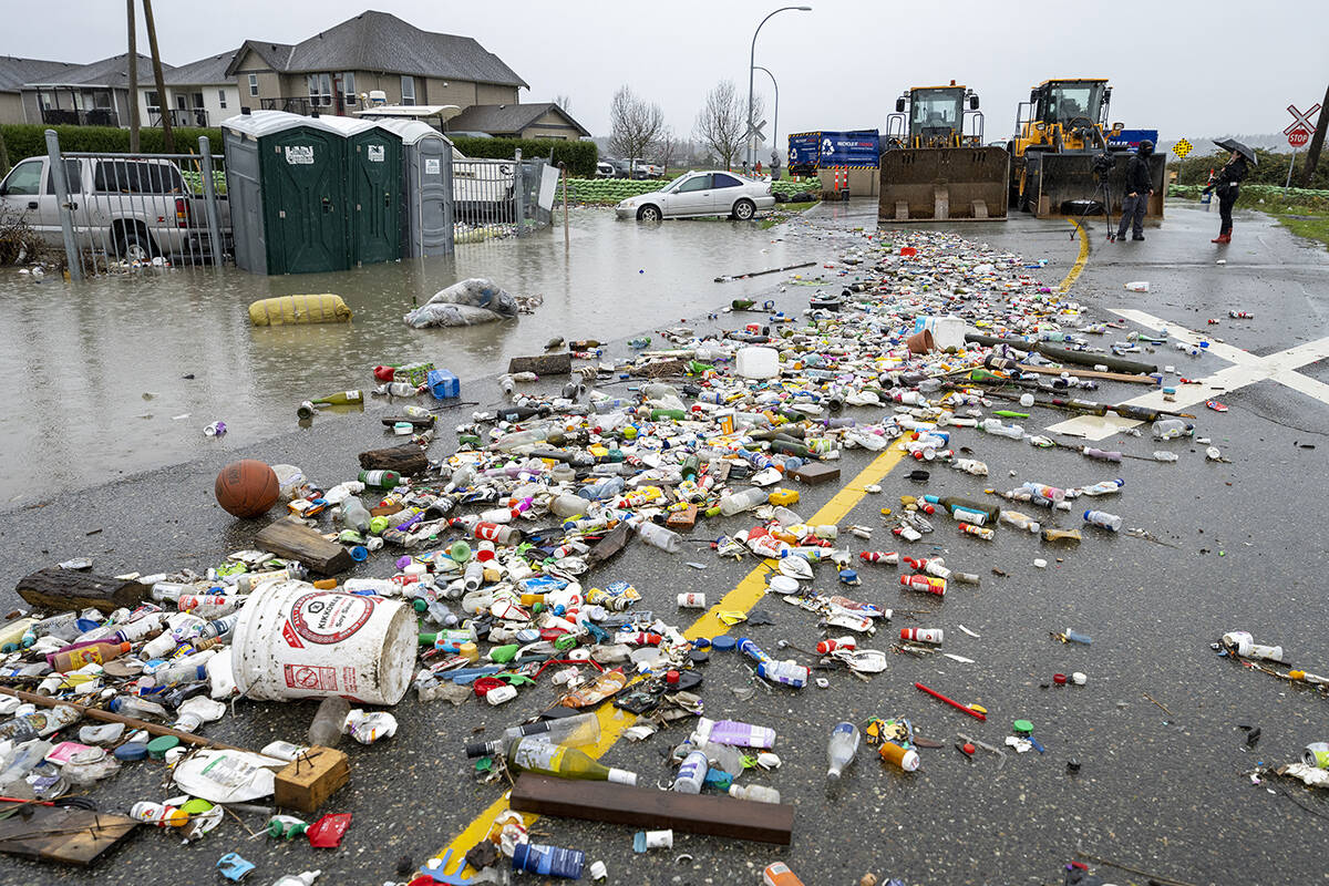 Debris from receding flood waters is pictured along a road as heavy rains form an atmospheric river continue in Abbotsford, B.C., Nov. 30, 2021. (THE CANADIAN PRESS/Jonathan Hayward)