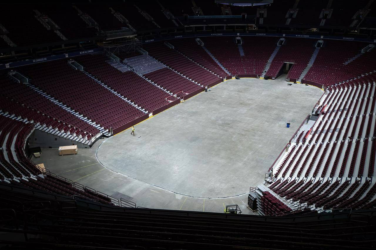 A worker sweeps the Rogers Arena floor where the ice has been removed for the summer as the Vancouver Canucks NHL hockey team’s home rink undergoes renovations and improvements to the off-ice areas, in Vancouver, B.C., Wednesday, July 13, 2022. Sportsnet will continue to broadcast Vancouver Canucks games on TV and radio for another decade. THE CANADIAN PRESS/Darryl Dyck