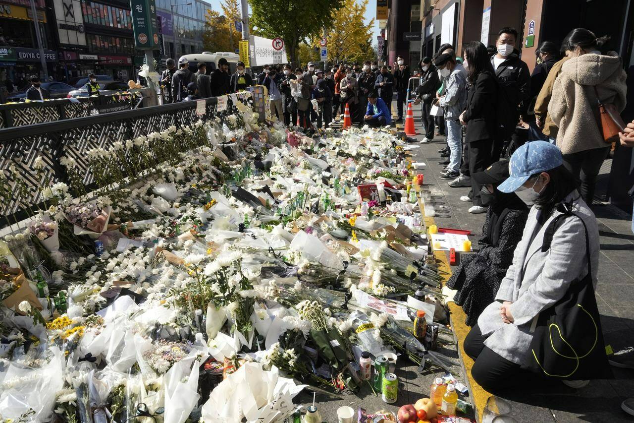 People pay tribute to victims of a deadly crowd crush during Saturday night’s Halloween festivities, at a makeshift flower-laying area set up near the scene of the incident in Seoul, South Korea, Wednesday, Nov. 2, 2022. THE CANADIAN PRESS/AP-Ahn Young-joon