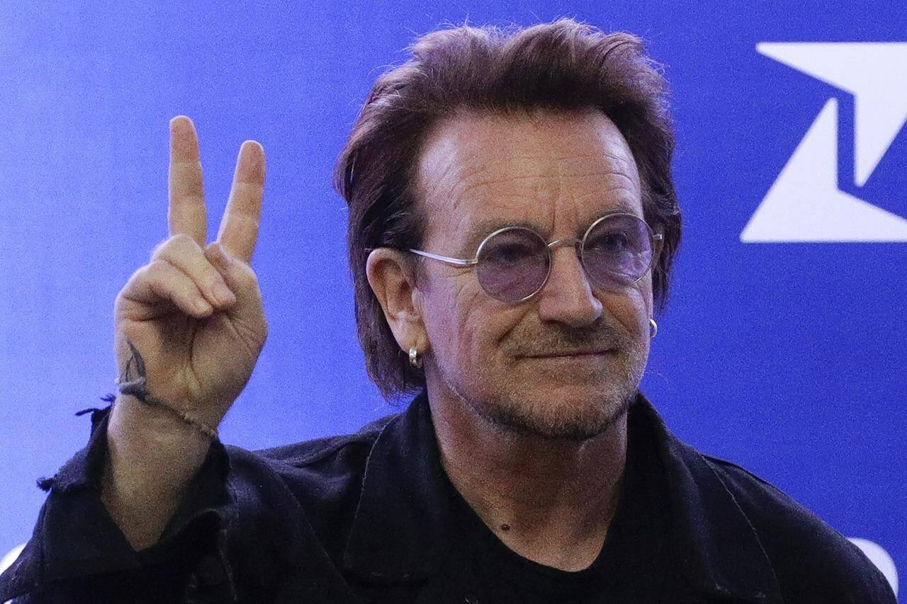 FILE - U2 singer Bono gestures as he attends the launching of the first blood by drone delivery service in the country at the Philippine Red Cross headquarters in suburban Mandaluyong, east of Manila, Philippines on Tuesday Dec. 10, 2019. Bono opened his book tour for his bestselling “Surrender: 40 Songs, One Story,” on Wednesday, Nov. 2, 2022, to thousands of screaming fans at Manhattan’s Beacon Theatre. (AP Photo/Aaron Favila, File)
