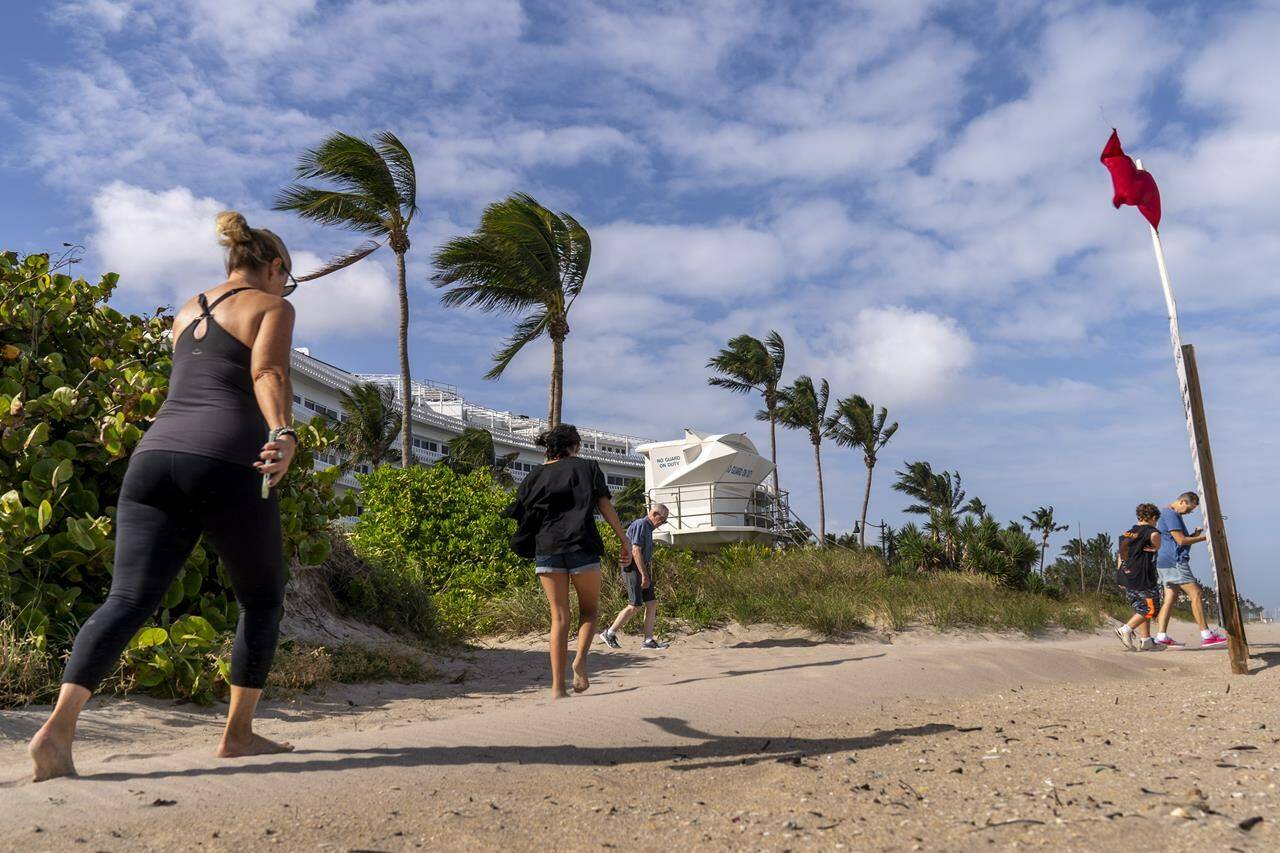A red flag, signaling high surf and strong currents, flies in strong wind on the beach in Palm Beach, Fla., Tuesday, Nov. 8, 2022, as Tropical Storm Nicole continues to increase in strength and is expected to make landfall along Florida’s east coast early Thursday. (AP Photo/Andrew Harnik)