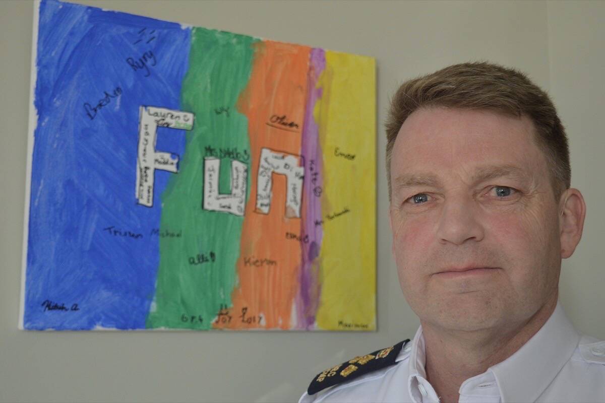 Surrey RCMP’s officer in charge, Assistant Commissioner Brian Edwards, with a painting his son did in Grade 4 that hangs in a place of honour on his office wall. (File photo: Tom Zytaruk)