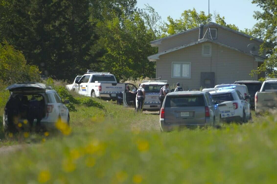 In this image taken from video, Canadian law enforcement personnel surrounded a residence on the James Smith Cree First Nation reservation in Saskatchewan on Tuesday, Sept. 6, 2022, as they search for a suspect in a series of stabbings. The federal government is to spend $1.2 million to repair and replace houses damaged during the stabbings. THE CANADIAN PRESS/AP-Robert Bumsted