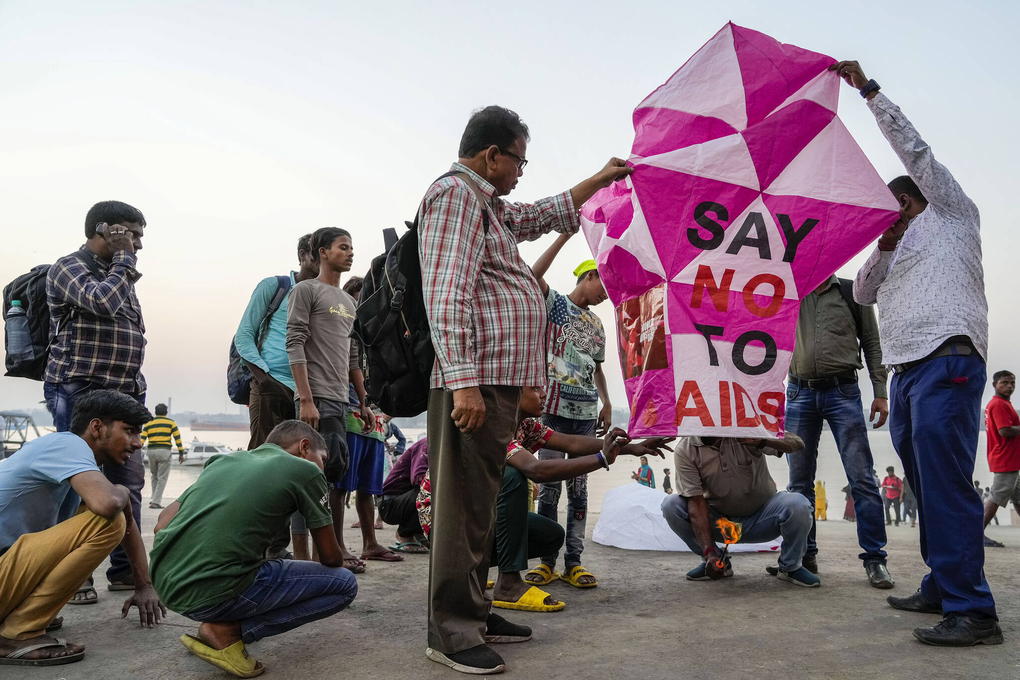 Activists prepare to release a sky lantern with a message on the banks of the Hooghly River ahead of World AIDS Day in Kolkata, India, Wednesday, Nov. 30, 2022. Every year, on 1 December, the world commemorates World AIDS Day. People around the world unite to show support for people living with and affected by HIV and to remember those who lost their lives to AIDS. (AP Photo/Bikas Das)