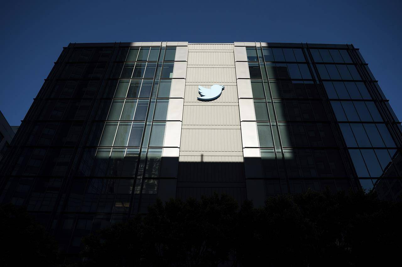 FILE - A Twitter logo hangs outside the company’s San Francisco offices on Tuesday, Nov. 1, 2022. The Washington Post’s Taylor Lorenz has become the latest journalist to be banned from Twitter. Lorenz says she and another Post technology reporter, Drew Harwell, were researching an article concerning Twitter CEO Elon Musk. (AP Photo/Noah Berger, File)