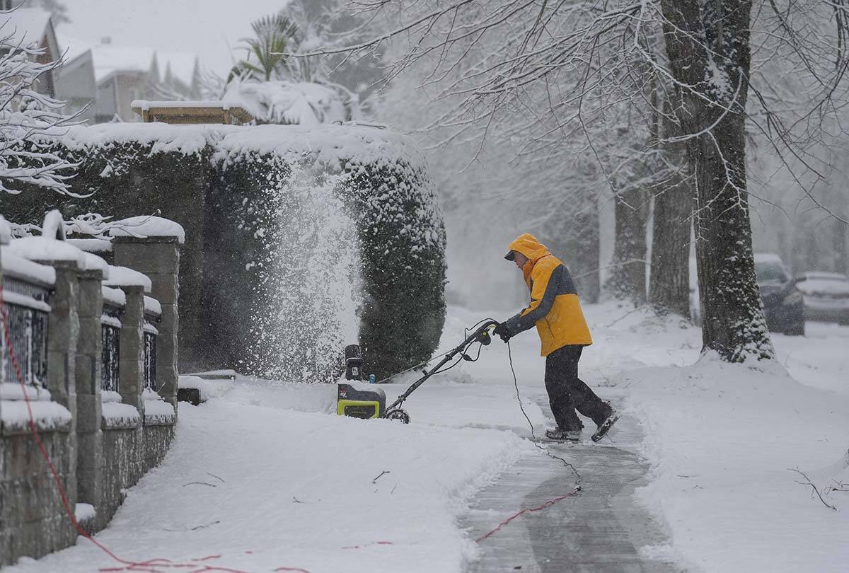 A man uses a snowblower to clear snow from a sidewalk in Vancouver, on Sunday, December 18, 2022. BC Hydro says holiday-time storms are on the rise in the province. THE CANADIAN PRESS/Darryl Dyck