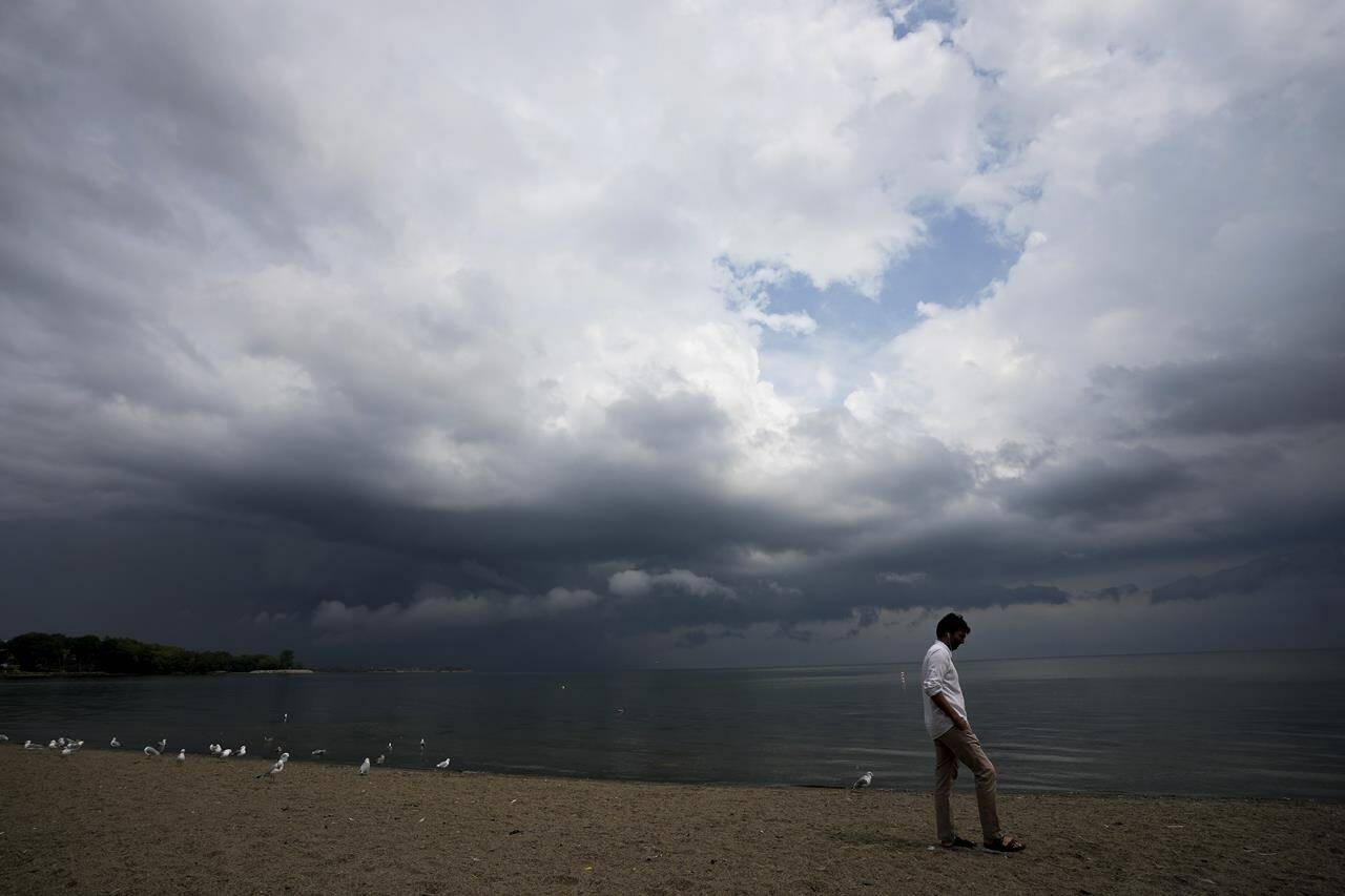A person looks out over Lake Ontario as a thunderstorm rolls through Toronto on Thursday, August 4, 2022. THE CANADIAN PRESS/Nathan Denette