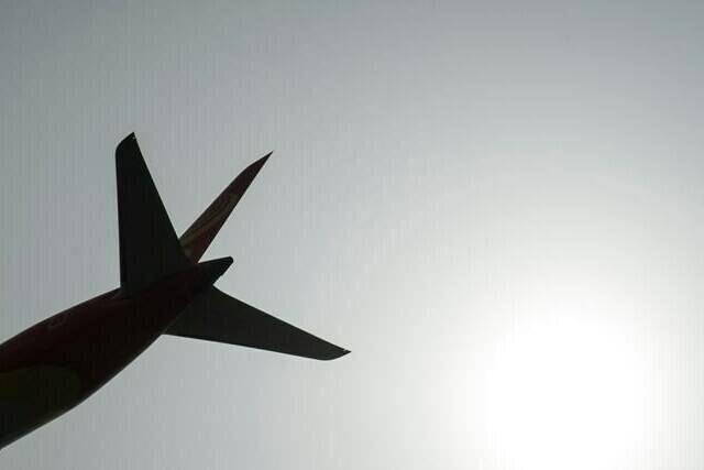 A plane is silhouetted as it takes off from Vancouver International Airport in Richmond, B.C., Monday, May 13, 2019. New Democrat Leader Jagmeet Singh says he wants to see more competition within Canada’s airspace in order to make flying more affordable for people.THE CANADIAN PRESS/Jonathan Hayward