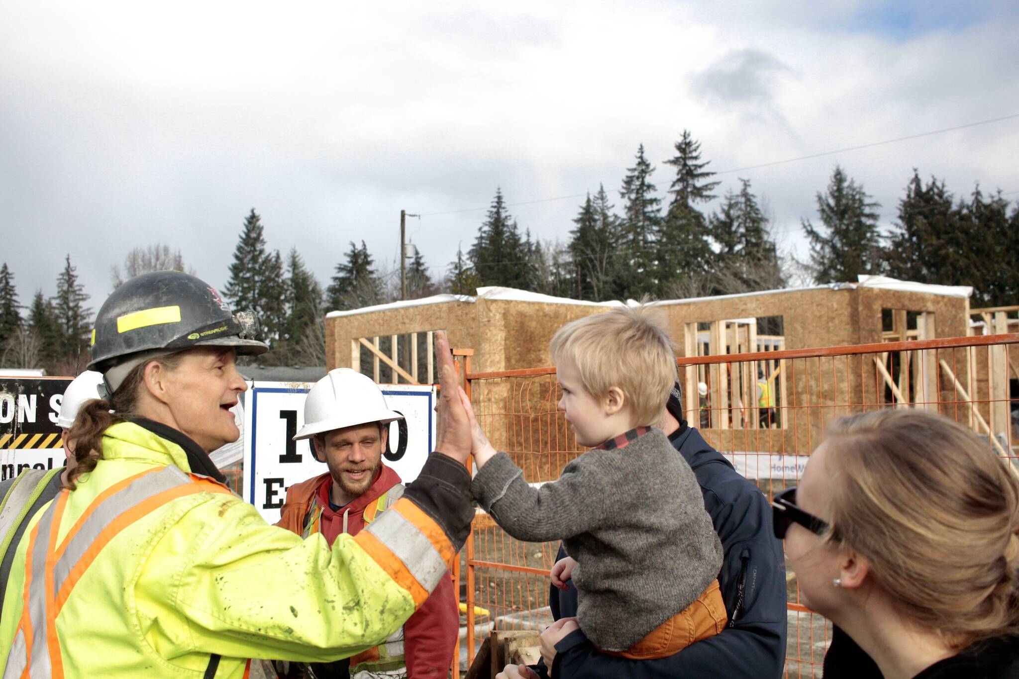 Phil Hillier (right) high fives a construction worker on Hillier’s third birthday. Photo by Marc Kitteringham/Campbell River Mirror