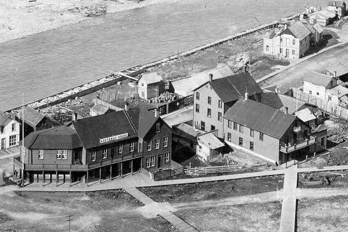 This historic photo is of the Kootenay Hotel to the left and the Queen's Hotel to the right.

The Kootenay sat where the 7-11 parking lots and pumps are in 2023. Dyking was well underway and the boardwalk through the downtown was quite extensive. 

~Golden Museum