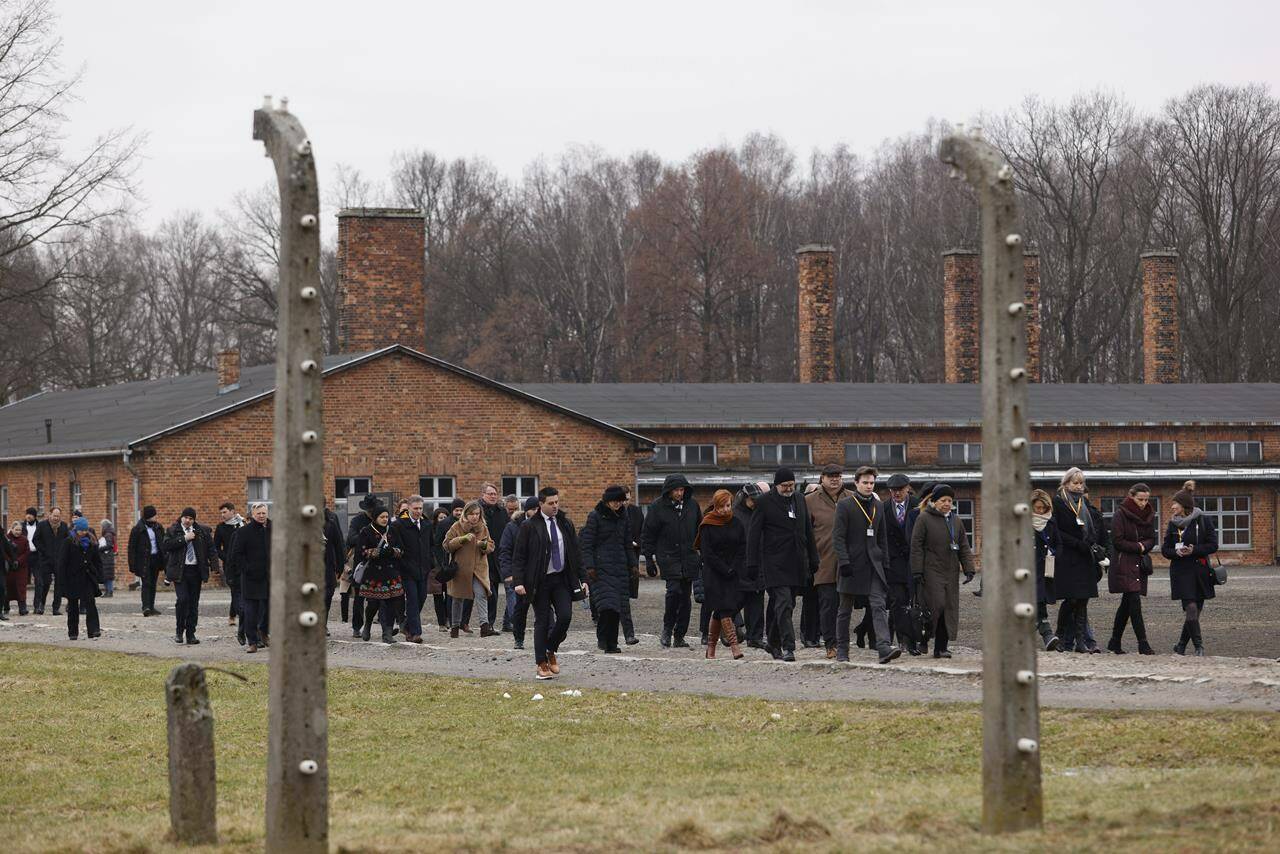 People attend a ceremony in the former Nazi German concentration and extermination camp Auschwitz during ceremonies marking the 78th anniversary of the liberation of the camp in Brzezinka, Poland, Friday, Jan. 27, 2023. (AP Photo/Michal Dyjuk)