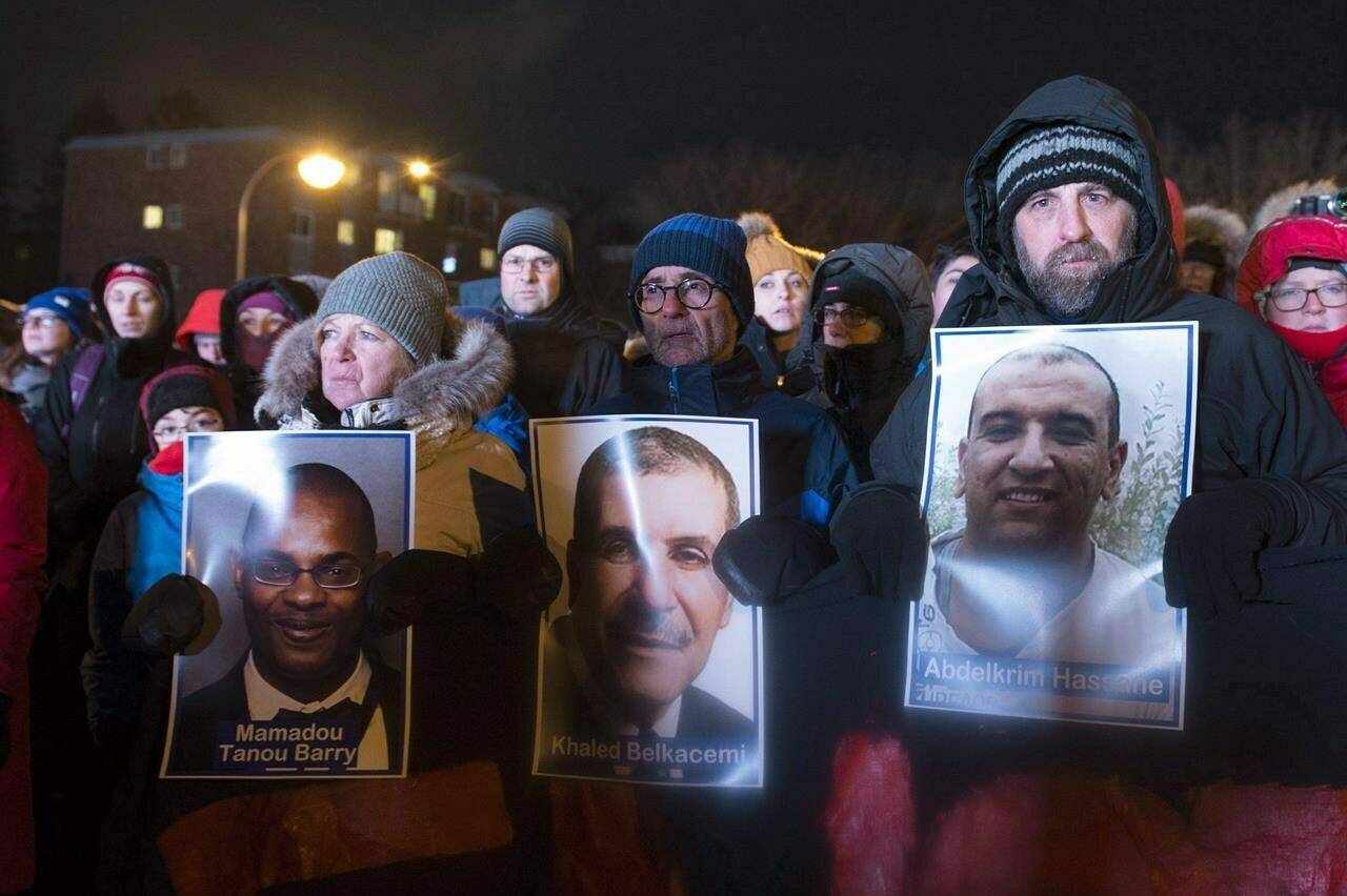 People hold pictures of the victims at a vigil to commemorate the one-year anniversary of the Quebec City mosque shooting, in Quebec City, Monday, Jan. 29, 2018. A ceremony will be held this evening to mark the sixth anniversary of Quebec City’s deadly mosque shooting. THE CANADIAN PRESS/Jacques Boissinot