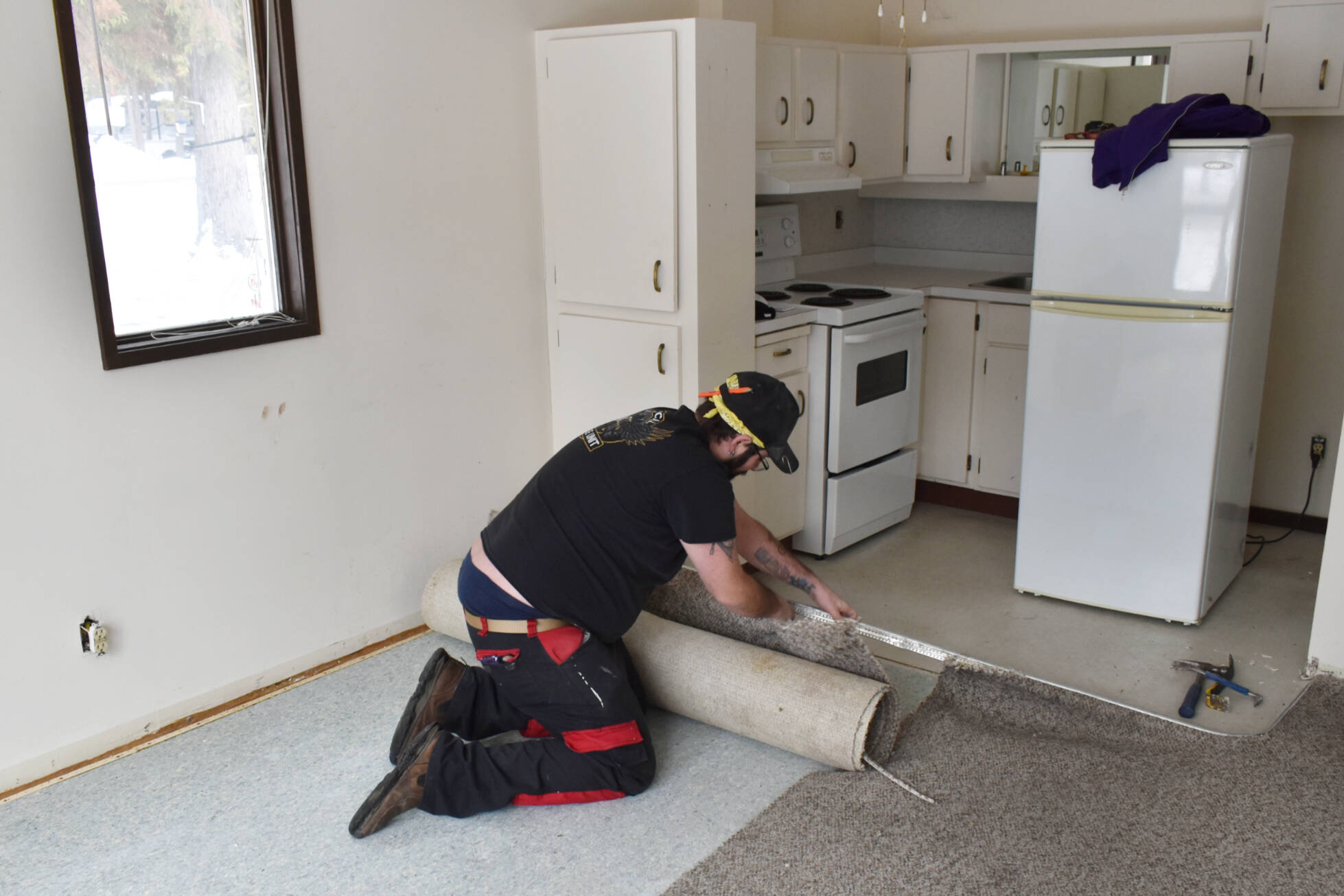 Jeff VanDooyeweert, Eagle Valley Road Rescue deputy chief, pulls up carpet in a unit at The Haven seniors’ living complex in Sicamous as the 48-year old unit undergoes a renovation. (Rebecca Willson- Eagle Valley News)