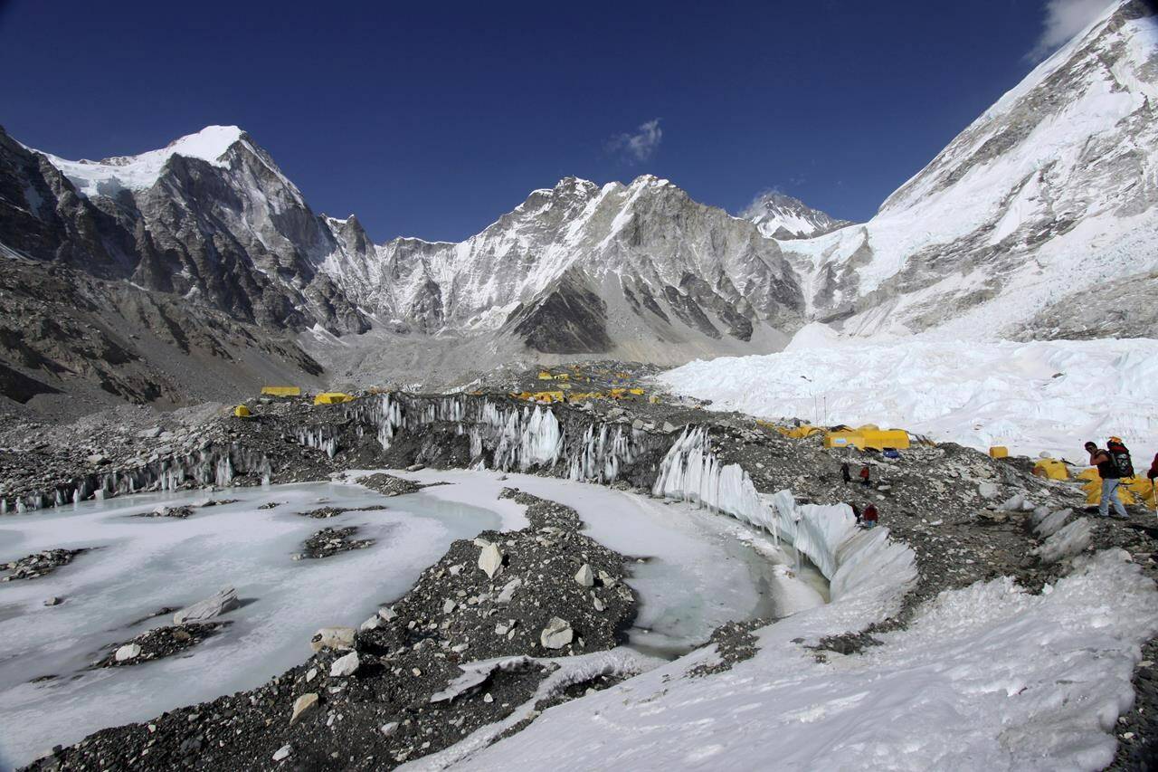 FILE - Tents are set up for climbers on the Khumbu Glacier, with Mount Khumbutse, center, and Khumbu Icefall, right, seen in background, at Everest Base Camp in Nepal on April 11, 2015. As glaciers melt and pour massive amounts of water into nearby lakes, 15 million people across the globe live under the threat of a sudden and deadly outburst flood, a new study finds. (AP Photo/Tashi Sherpa, File)