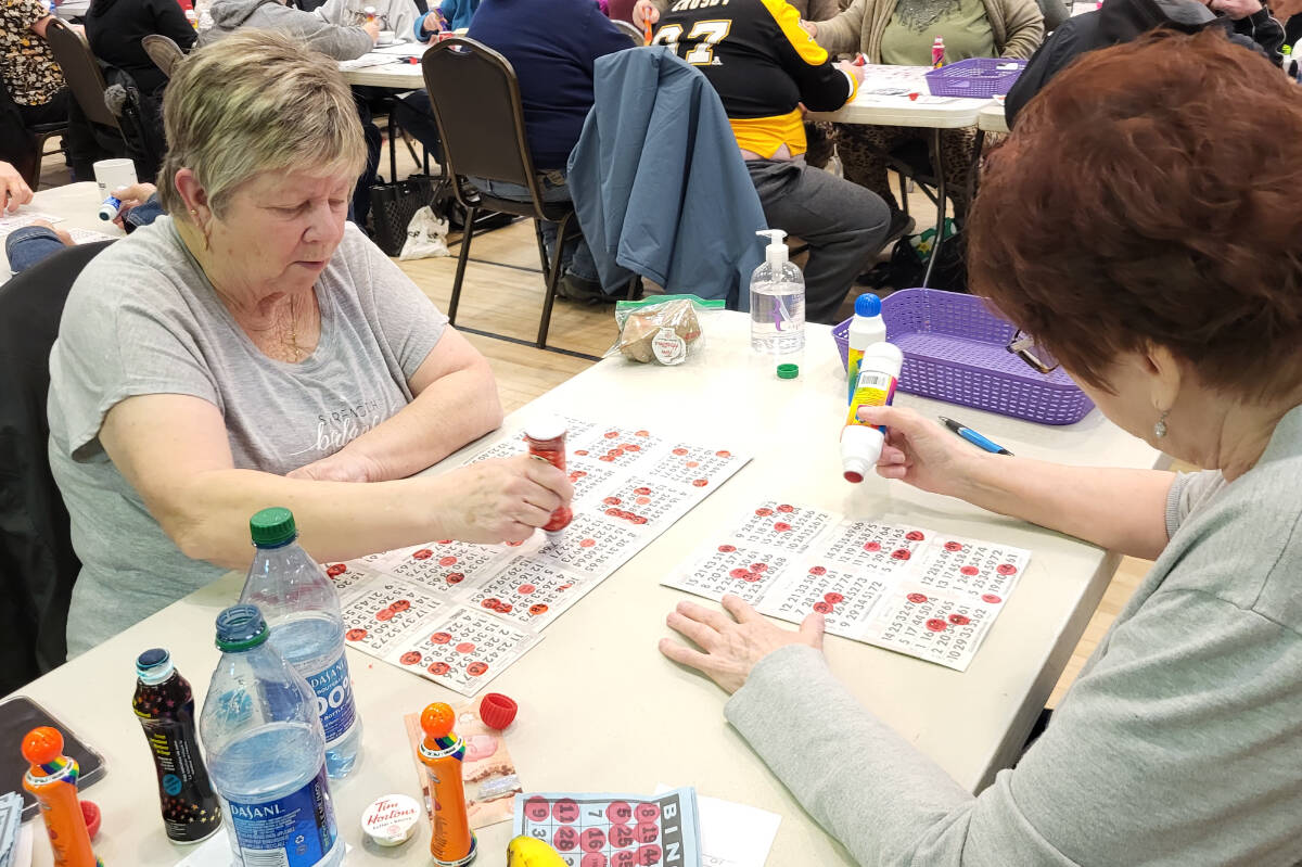 Lake Country players Bonnie Larocque (left) and Chris Calcutt keep close tabs on their cards during the Vernon Winter Carnival Bingo Marathon Tuesday, Feb. 7, at the Halina Activity Centre. Each woman won at least one game. (Roger Knox - Morning Star)