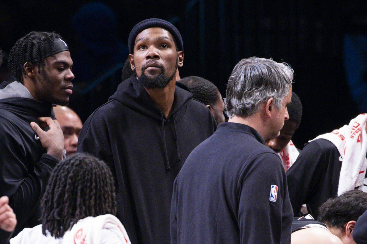 Brooklyn Nets forward Kevin Durant, center, looks on from the bench during the second half of an NBA basketball game against the Los Angeles Lakers, Monday, Jan. 30, 2023, in New York. (AP Photo/Corey Sipkin)