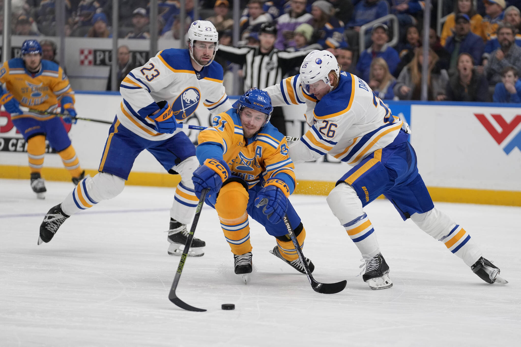 St. Louis Blues’ Vladimir Tarasenko (91) reaches for a loose puck as Buffalo Sabres’ Rasmus Dahlin (26) and Mattias Samuelsson (23) defend during the second period of an NHL hockey game Tuesday, Jan. 24, 2023, in St. Louis. (AP Photo/Jeff Roberson)