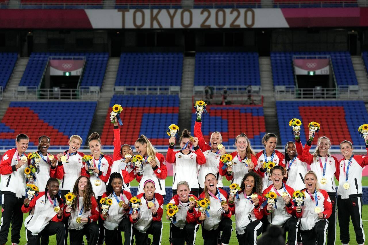 Players of Canada pose with their gold medals after defeating Sweden in the women’s final soccer match at the 2020 Summer Olympics, Saturday, Aug. 7, 2021, in Yokohama, Japan. The Canadian women’s soccer team has slammed Canada Soccer, saying it is “outraged and deeply concerned with the news of significant cuts” to national team programs for 2023.THE CANADIAN PRESS/AP, Andre Penner