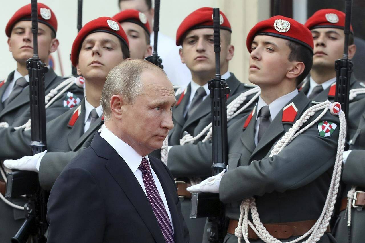 FILE - Russian President Vladimir Putin review the honor guards as he arrives for a meeting with Austrian President Alexander Van Der Bellen in Vienna, Austria, on June 5, 2018. Neutral Austria has come under heavy criticism for granting visas to sanctioned Russian lawmakers for a meeting of the Organization for Security and Cooperation in Europe in Vienna from Feb. 23 until Feb. 24, 2023. The issue highlights the delicate balancing act the European country has engaged in while trying to maintain its longstanding position of military neutrality during the war in Ukraine. (AP Photo/Ronald Zak, File)