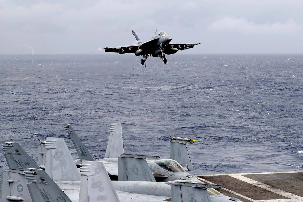 FILE - In this Aug. 6, 2019, file photo, a U.S. fighter jet prepares to land on the U.S. aircraft carrier USS Ronald Reagan following their patrol at the international waters off the South China Sea. (AP Photo/Bullit Marquez, File)