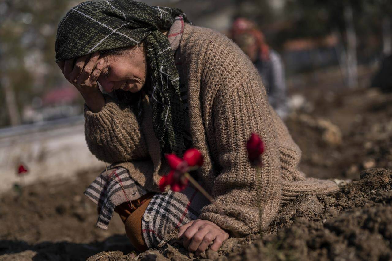 A member of the Vehibe family mourns a relative during the burial of one of the earthquake victims that struck a border region of Turkey and Syria five days ago in Antakya, southeastern Turkey, on Saturday, February 11, 2023. (AP Photo/Bernat Armangue)