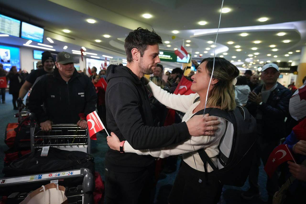 A woman embraces a member of the Burnaby Urban Search and Rescue Team as they are greeted by members of the Turkish Canadian community upon arrival from Turkey at Vancouver International Airport, in Richmond, B.C., on Tuesday, February 14, 2023. The team of volunteer search and rescue experts, which is mostly comprised of firefighters from Burnaby, deployed to Turkey the day after last week’s 7.8 magnitude earthquake. THE CANADIAN PRESS/Darryl Dyck