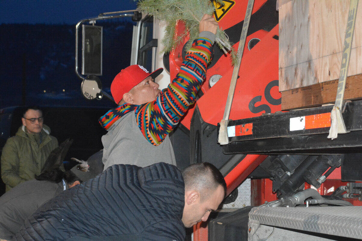 Williams Lake First Nation Chief Willie Sellars, cultural coordinator David Archie and Kerry Chelsea of Esk’etemc participate in a brushing ceremony on the truck carrying the repatriated Nuxalk totem pole at Sugar Cane Wednesday, Feb. 15 . (Monica Lamb-Yorski photo - Williams Lake Tribune)