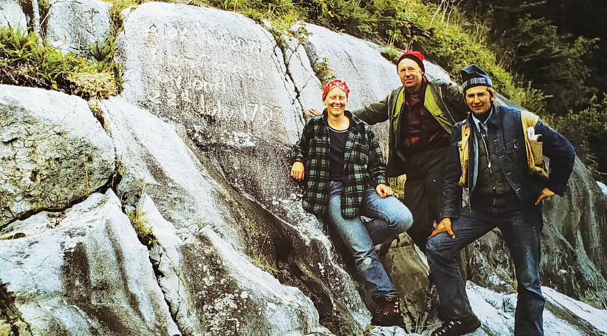 After completing the first field season work for Parks Canada, BC Parks and the Nature Conservancy of Canada in August 1975, Linda Flygare, left, John Woodworth and Hälle Flygare pose at the rock where Alexander Mackenzie mixed up some vermillion in melted grease, and inscribed, in large characters, on the southeast face of the rock on which he and his crew had slept, Alexander Mackenzie, from Canada, by land, the twenty-second of July, one thousand seven hundred and ninety-three. (Photo courtesy of Hälle Flygare)