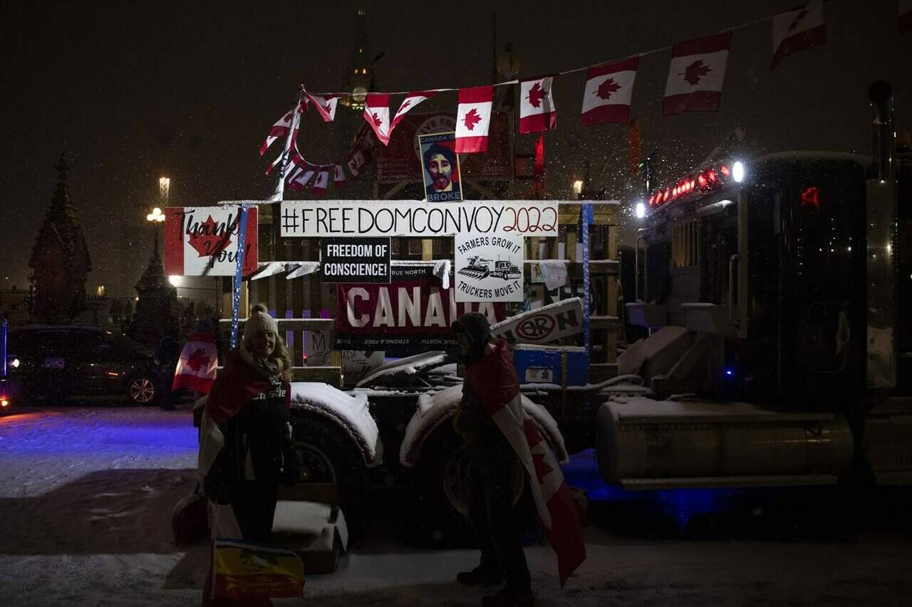 Snow falls as protesters stand by a semi-trailer truck on Wellington Street, on the 21st day of a protest against COVID-19 measures that had grown into a broader anti-government protest, in Ottawa, on Thursday, Feb. 17, 2022. Justice Paul Rouleau says the Canada Border Services Agency made a bad situation worse when it mishandled the announcement of a vaccine mandate for truckers early last year, amid rampant anger and false information around the pandemic. THE CANADIAN PRESS/Justin Tang