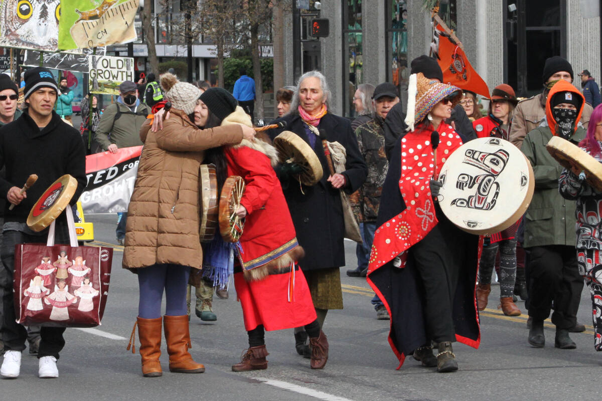Two women leading the march down Douglas Street Feb.25 take a moment to hug. (Hollie Ferguson/News Staff)
