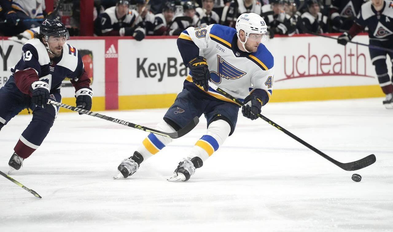 St. Louis Blues center Ivan Barbashev, right, looks to pass the puck as Colorado Avalanche defenseman Samuel Girard pursues in the second period of an NHL hockey game Saturday, Jan. 28, 2023, in Denver. (AP Photo/David Zalubowski)