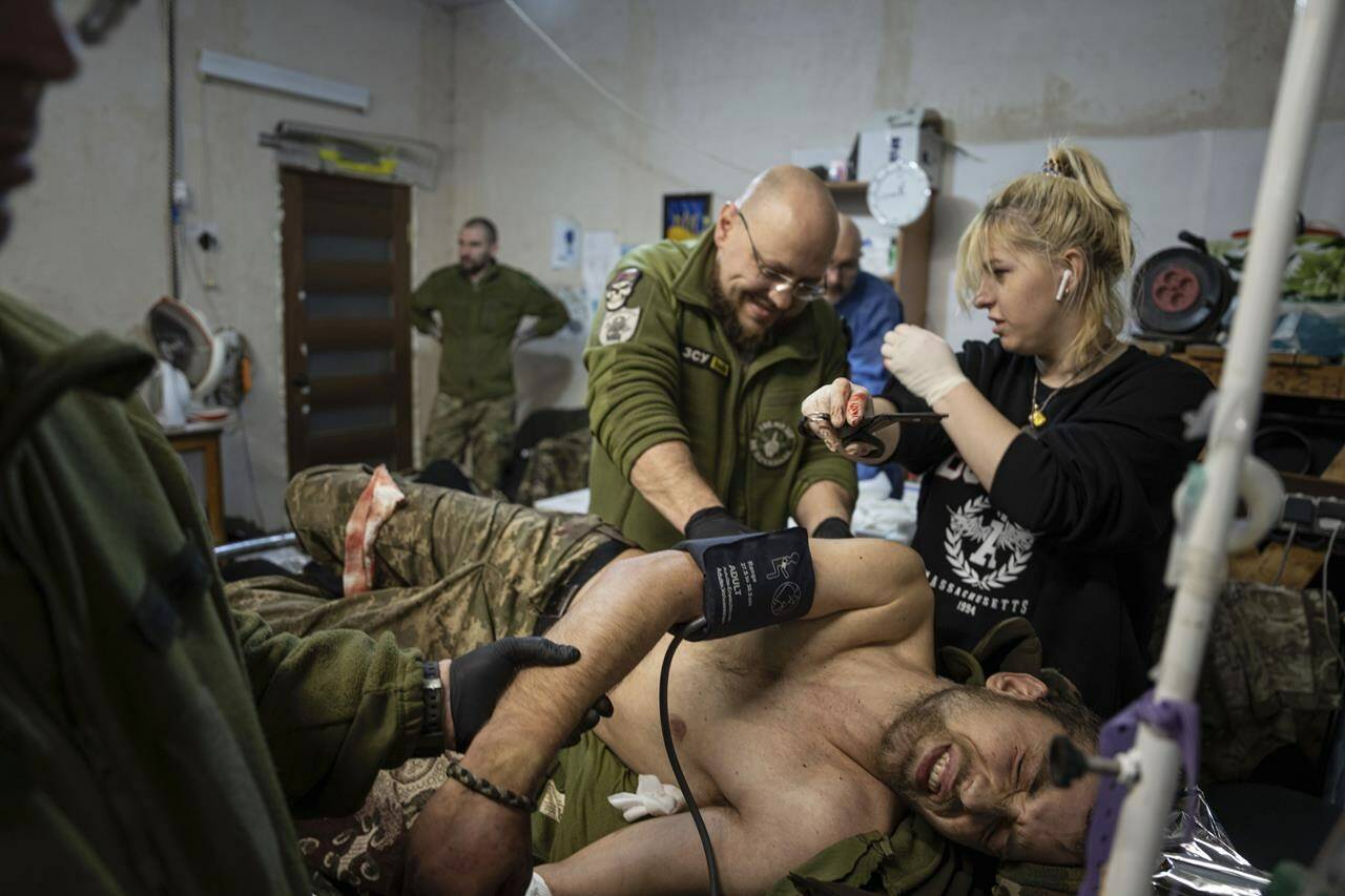 Ukrainian military medics treat their wounded comrade at the field hospital near Bakhmut, Ukraine, Sunday, Feb. 26, 2023. (AP Photo/Evgeniy Maloletka)