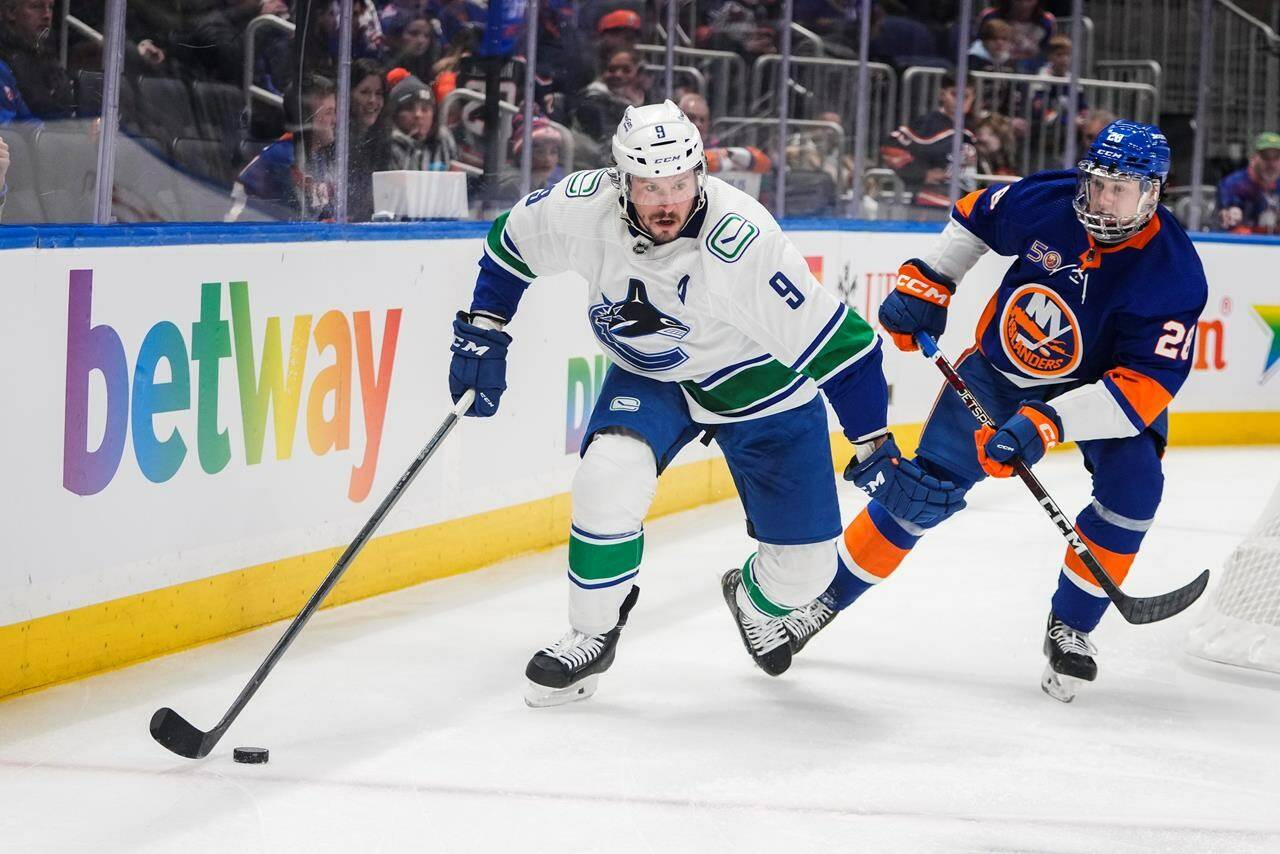 Vancouver Canucks’ J.T. Miller (9) competes for control of the puck with New York Islanders’ Alexander Romanov (28) during the first period of an NHL hockey game Thursday, Feb. 9, 2023, in Elmont, N.Y. Miller is out week-to-week with a lower-body injury, the team announced Monday. THE CANADIAN PRESS/AP-Frank Franklin II)