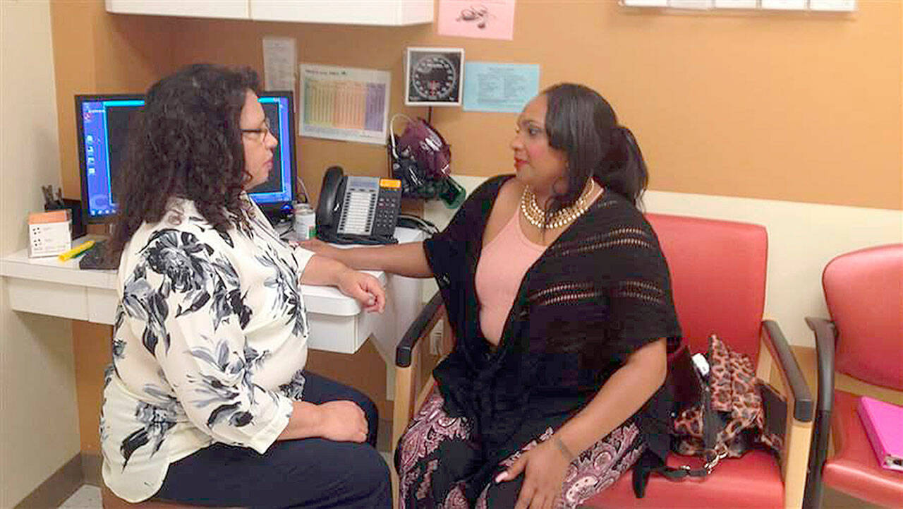 Paula Brown, a community health worker with Minneapolis’ Hennepin County Medical Center, consults with a patient. (Michael Ollove/Pew Charitable Trusts/TNS)