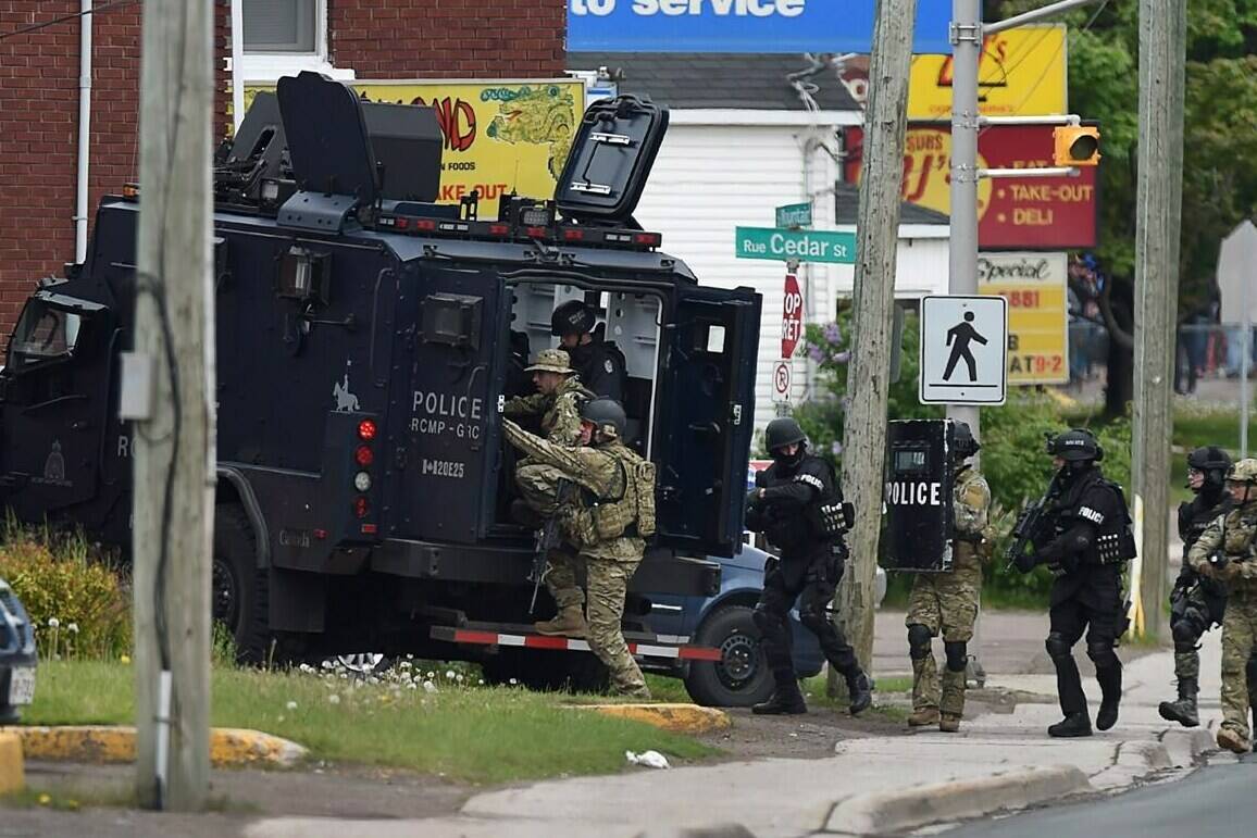 Emergency response officers enter a residence in Moncton, N.B., on Thursday, June 5, 2014. Three RCMP officers were killed and two injured by a gunman wearing military camouflage and wielding two guns on Wednesday. Police have identified a suspect as 24-year-old Justin Bourque of Moncton. THE CANADIAN PRESS/Andrew Vaughan