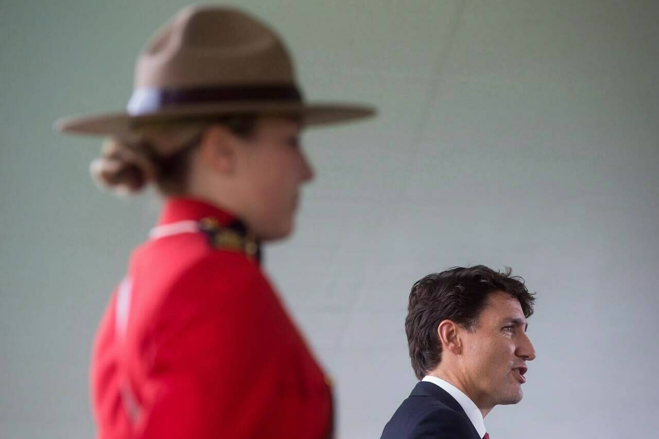 An RCMP officer stands by as Prime Minister Justin Trudeau addresses new Canadians during a citizenship ceremony in Kelowna, B.C., Wednesday, Sept. 6, 2017. Trudeau says having an Indigenous person serve as the next RCMP commissioner is “an excellent idea.” THE CANADIAN PRESS/Darryl Dyck