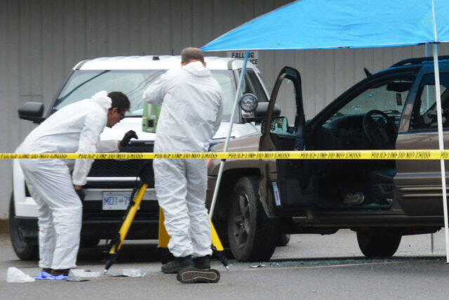 Investigators examine an SUV with bullet holes in its windshield and door in the parking lot of the Quesnel Seniors’ Centre following a police-involved shooting incident that happened Tuesday, Aug. 31, 2021 at about 3:30 a.m. (Cassidy Dankochik Photo - Quesnel Cariboo Observer)