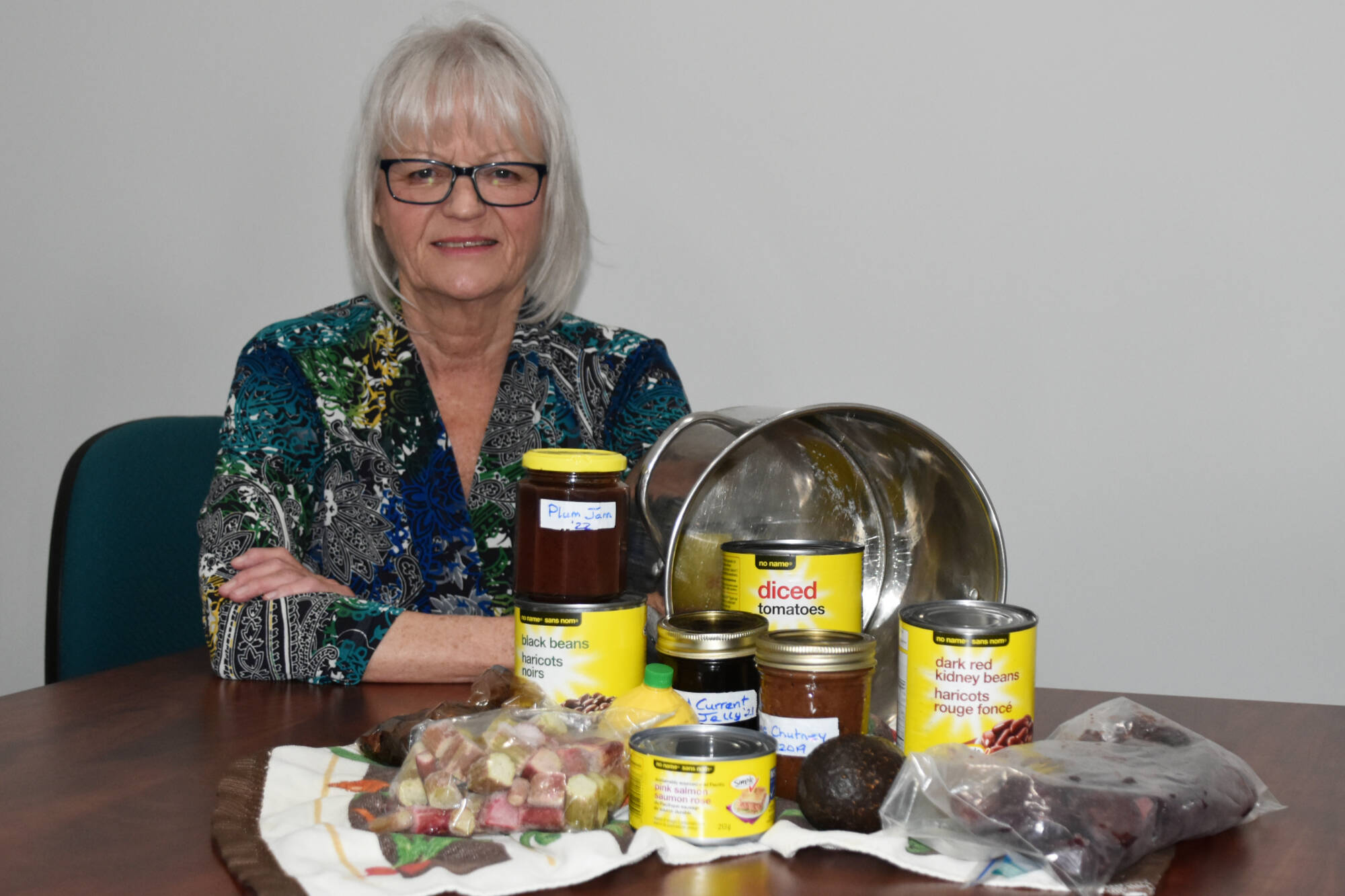 Salmon Arm’s Nan Gray sits with some of her preserves, ‘yellow’ cans, and bags of frozen foods, which have been staples of her frugal diet for years. (Martha Wickett - Salmon Arm Observer)