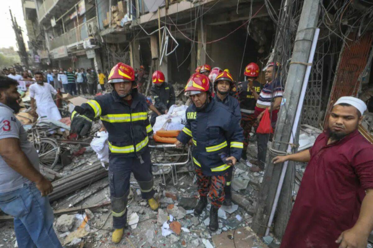 Fire officials carry a body of a victim after an explosion, in Dhaka, Bangladesh, Tuesday, March 7, 2023. An explosion in a seven-story commercial building in Bangladesh's capital has killed at least 14 people and injured dozens. Officials say the explosion occurred in a busy commercial area of Dhaka. (AP Photo/Abdul Goni)