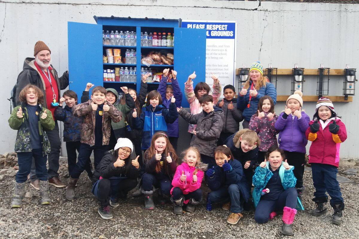 The St. James Grade 2 class, along with teachers Mr. Royal and Mrs. Kilarski, as well as parent volunteer Julie Useda outside at the school’s blessing box. (Contributed)