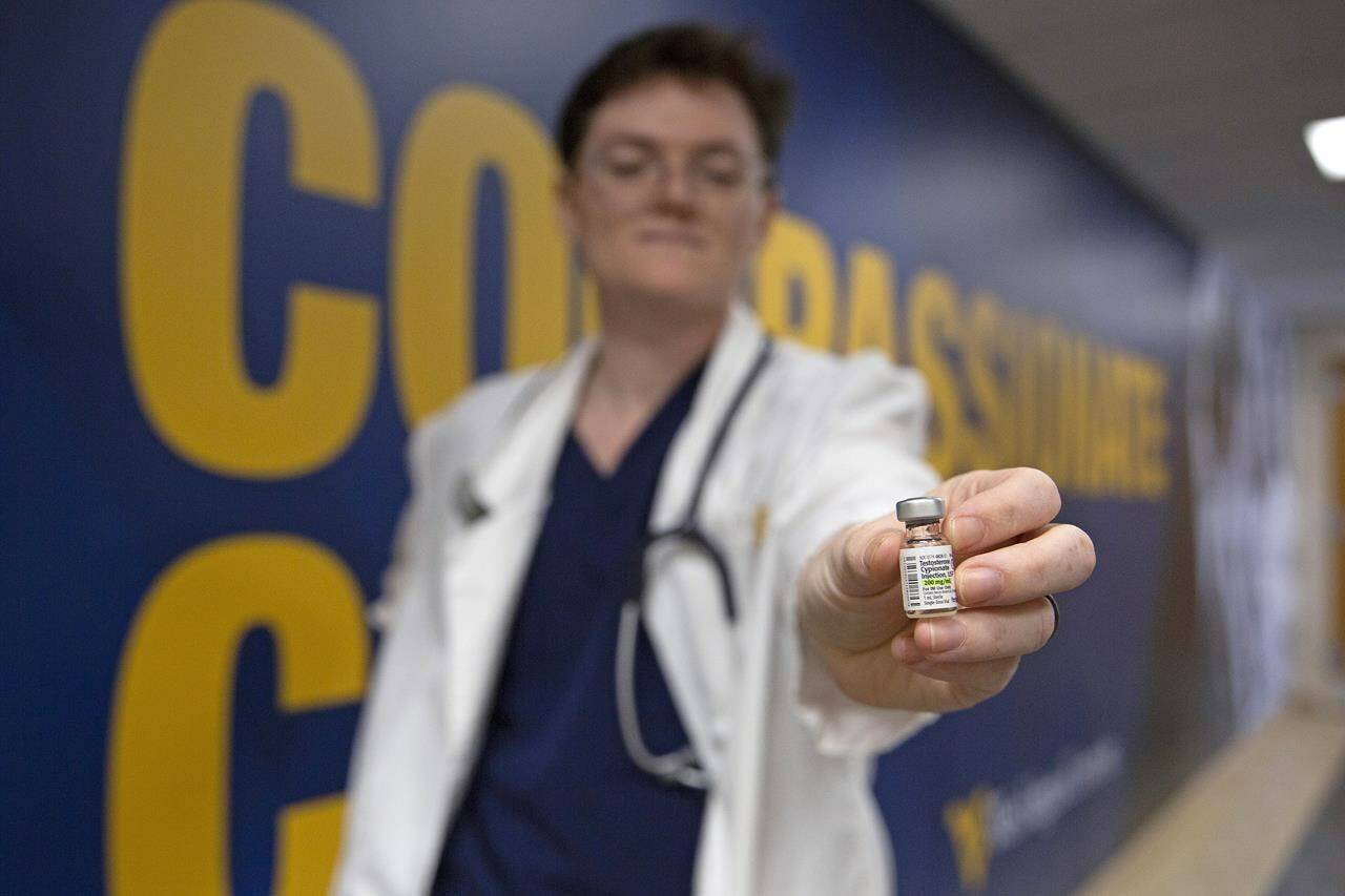 West Virginia University student El Didden holds a vial of testosterone cypionate that is used for hormone therapy on Wednesday, March 8, 2023, in Morgantown, W.Va. (AP Photo/Kathleen Batten)